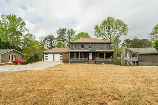 view of front of home with a garage, a front lawn, roof with shingles, driveway, and covered porch