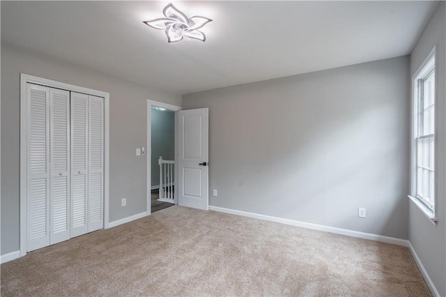 unfurnished bedroom with baseboards, a closet, and carpet
