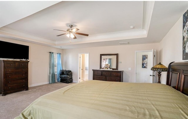 carpeted bedroom with connected bathroom, a tray ceiling, ceiling fan, and crown molding