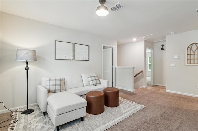 living area featuring carpet, attic access, baseboards, an upstairs landing, and visible vents