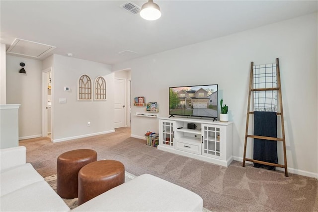 living room with carpet flooring, baseboards, visible vents, and attic access