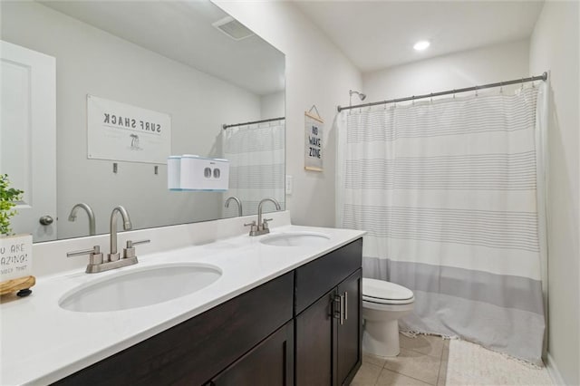 full bathroom featuring a sink, tile patterned floors, toilet, and double vanity