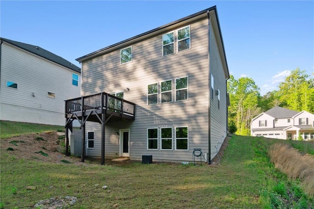 back of house featuring a lawn and a deck
