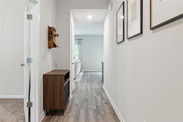 hall featuring recessed lighting, baseboards, and light wood finished floors