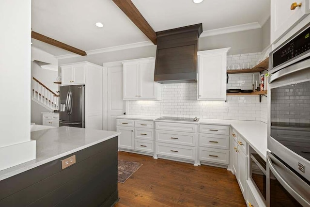 kitchen with white cabinetry, stainless steel appliances, custom exhaust hood, and beamed ceiling