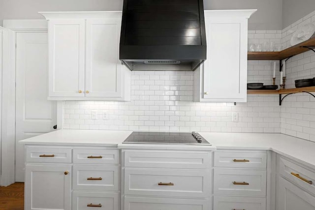 kitchen featuring decorative backsplash, white cabinets, and wall chimney exhaust hood