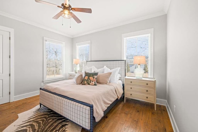 bedroom featuring dark hardwood / wood-style flooring, multiple windows, ornamental molding, and ceiling fan