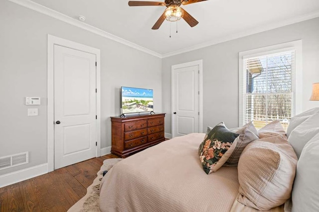 bedroom with crown molding, dark hardwood / wood-style floors, and ceiling fan