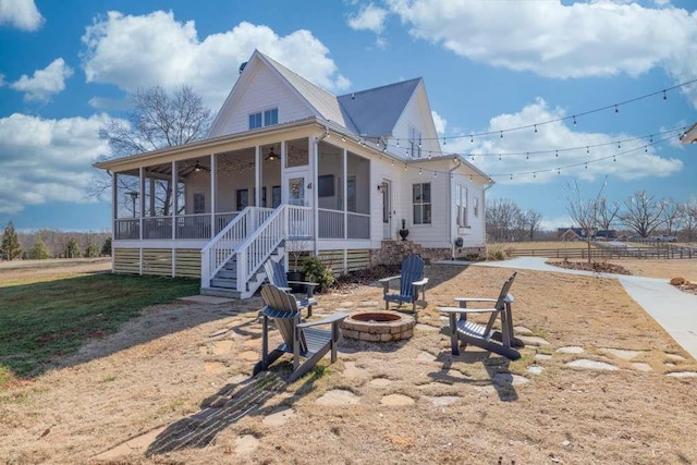 view of front of home featuring a sunroom and a fire pit