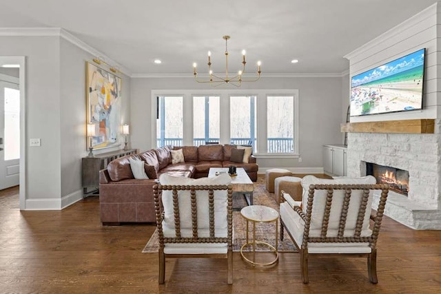 living room featuring dark hardwood / wood-style flooring, crown molding, a stone fireplace, and a chandelier