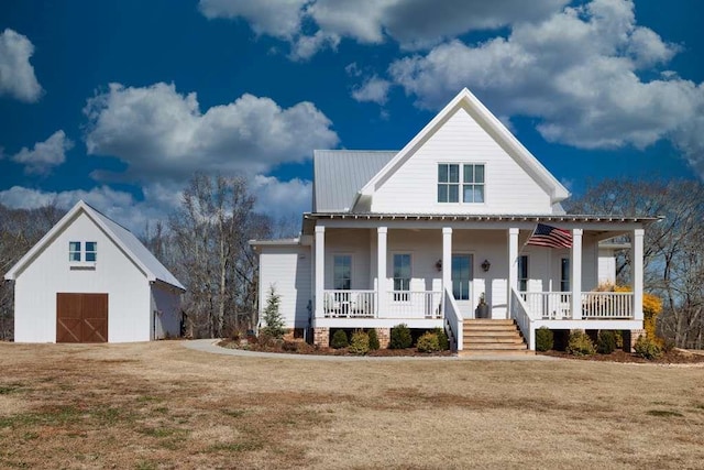 view of front of house featuring a front yard, covered porch, and a shed