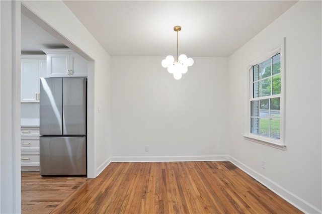 3480 Mount Olive Rd, Atlanta, GA 30344 - unfurnished dining area featuring a chandelier, wood finished floors, and baseboards