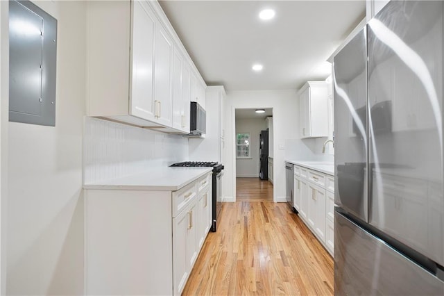 3480 Mount Olive Rd, Atlanta, GA 30344 - kitchen with stainless steel appliances, electric panel, light countertops, light wood finished floors, and a sink