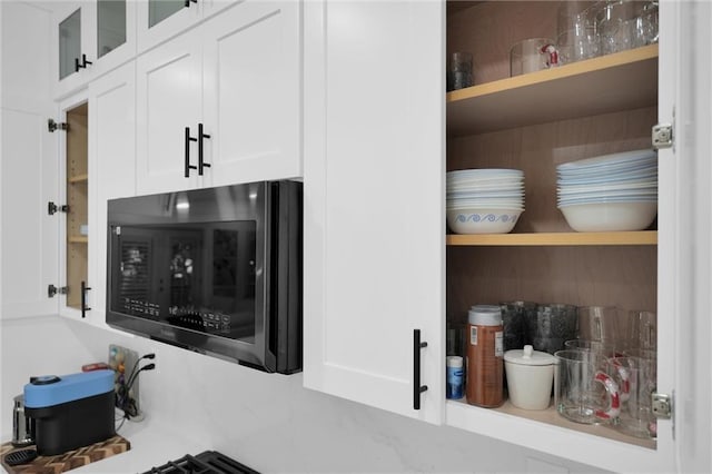 208 Wade Creek Rd, Alpharetta, GA 30009 - kitchen view of black microwave, open shelves, white cabinets, and glass insert cabinets