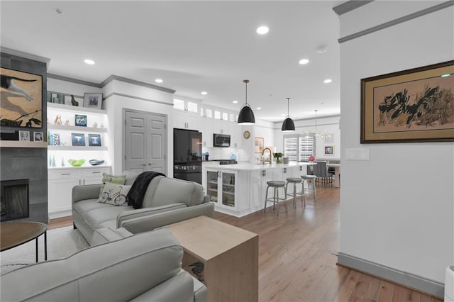 208 Wade Creek Rd, Alpharetta, GA 30009 - living area featuring a fireplace, wood finished floors, recessed lighting, a chandelier, and crown molding