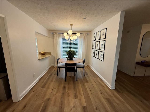 dining space featuring hardwood / wood-style floors, a chandelier, and a textured ceiling