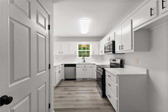 60 Weeping Willow Ln, Dawsonville, GA 30534 - kitchen featuring stainless steel appliances, light wood-style floors, white cabinetry, light countertops, and a sink