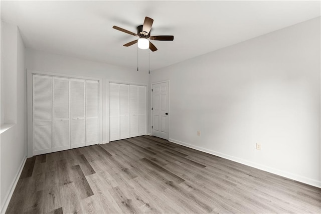 60 Weeping Willow Ln, Dawsonville, GA 30534 - unfurnished bedroom featuring multiple closets, wood finished floors, baseboards, and ceiling fan