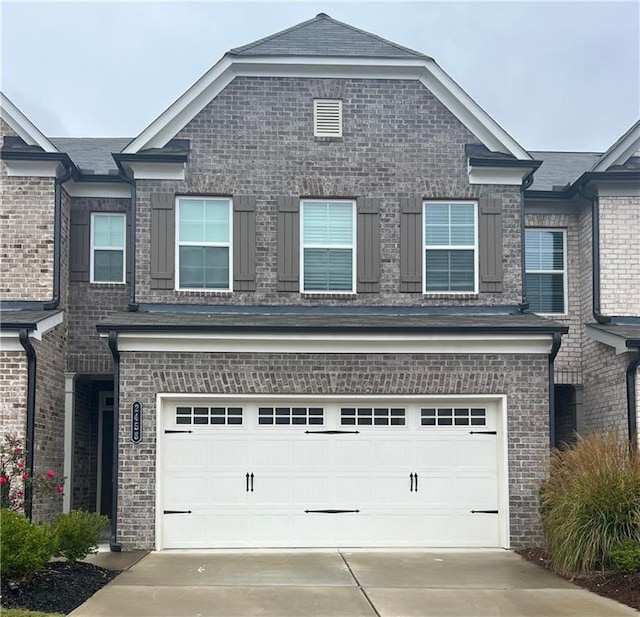 view of front of property with concrete driveway, brick siding, and an attached garage