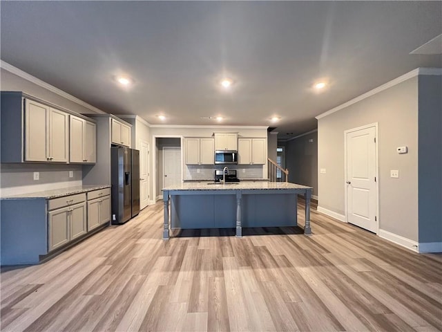 kitchen with stainless steel microwave, ornamental molding, a sink, baseboards, and black fridge