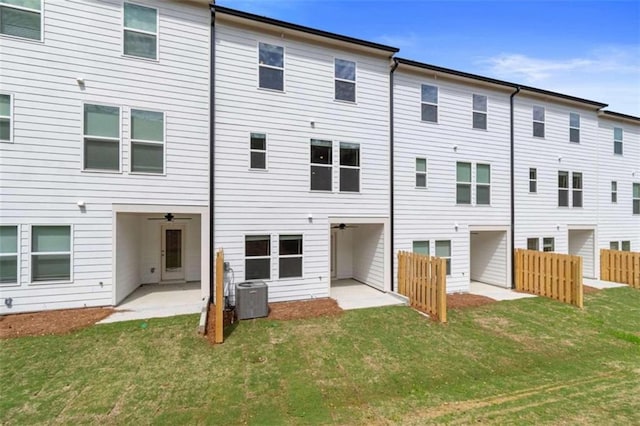 back of property with a patio area, central air condition unit, and a lawn