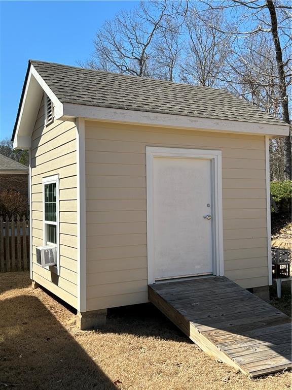 view of shed with fence and cooling unit