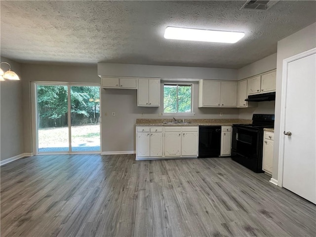 33 Drew Ct, Jonesboro, GA 30238 - kitchen featuring black appliances, under cabinet range hood, white cabinets, a textured ceiling, and light wood-style flooring