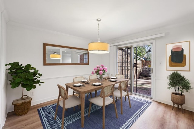 dining space with hardwood / wood-style floors and ornamental molding