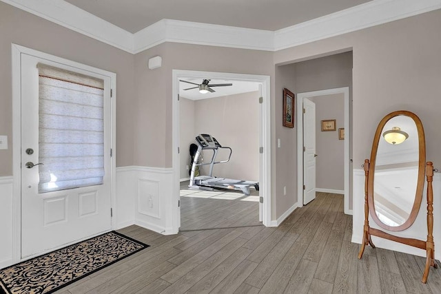 foyer entrance with ceiling fan, light hardwood / wood-style floors, and ornamental molding