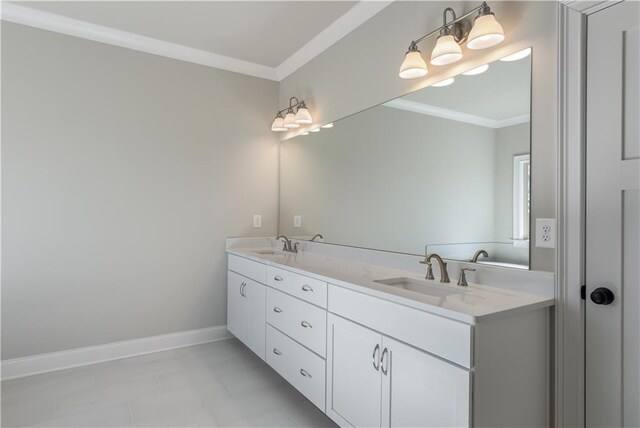 bathroom with a sink, ornamental molding, and baseboards