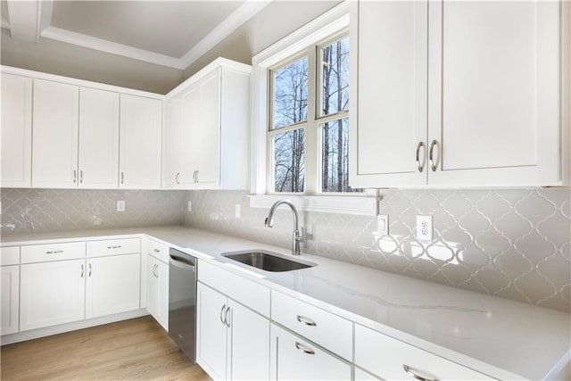 kitchen featuring white cabinets, crown molding, a sink, light stone counters, and stainless steel dishwasher