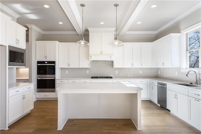 kitchen with under cabinet range hood, a sink, beam ceiling, appliances with stainless steel finishes, and wood finished floors