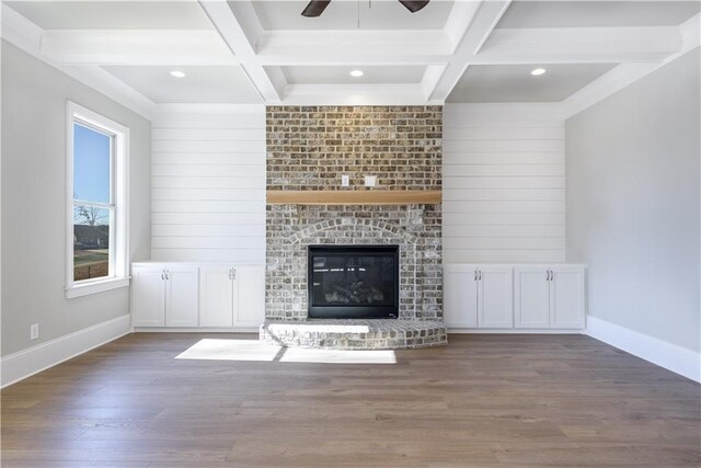 unfurnished living room featuring coffered ceiling, baseboards, beamed ceiling, ceiling fan, and wood finished floors