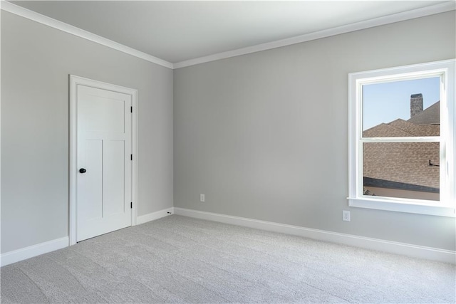 empty room featuring a healthy amount of sunlight, carpet, baseboards, and crown molding