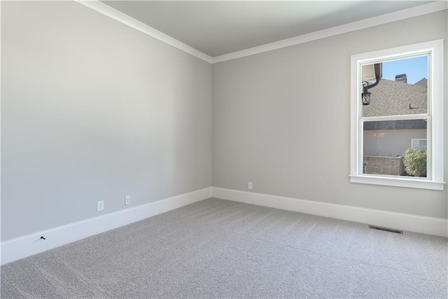 carpeted empty room featuring baseboards, visible vents, and ornamental molding