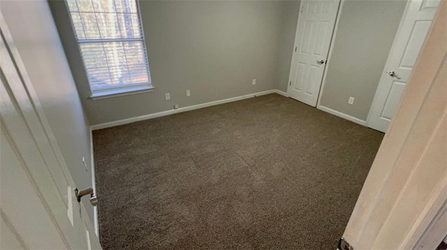 unfurnished bedroom featuring dark carpet