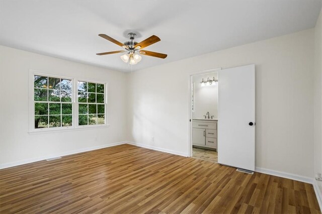 unfurnished room with a chandelier, hardwood / wood-style floors, and wooden walls