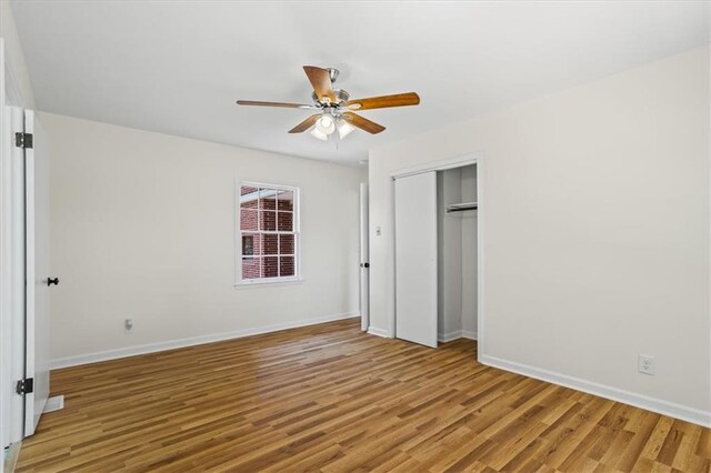 unfurnished dining area featuring ceiling fan with notable chandelier and wood-type flooring