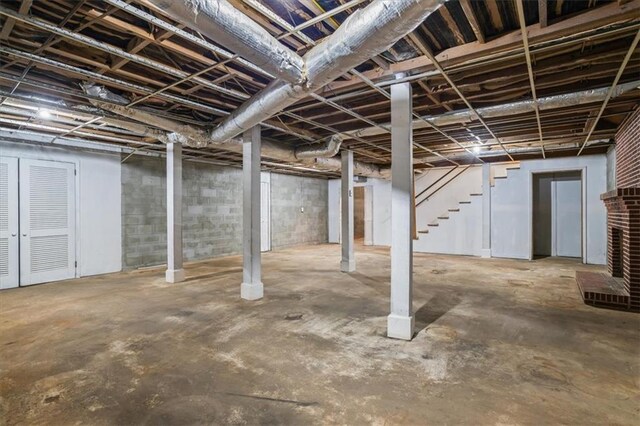 unfurnished living room with ceiling fan, wood walls, hardwood / wood-style floors, and a brick fireplace