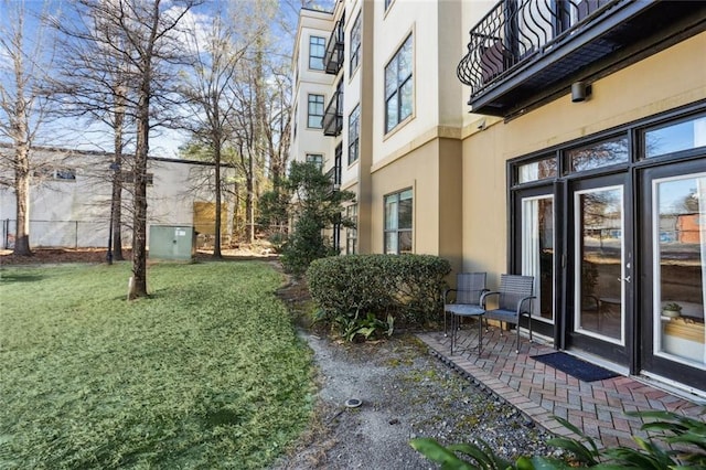 view of yard featuring a patio and a balcony