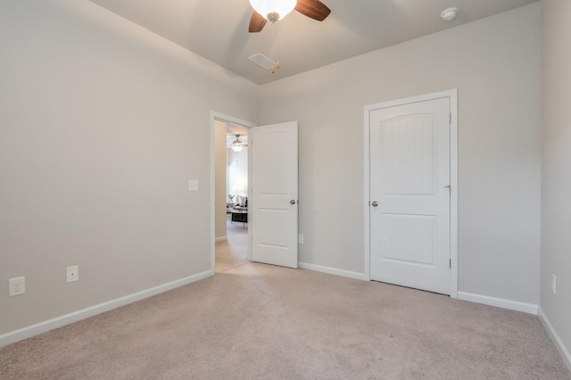 unfurnished bedroom featuring light carpet and ceiling fan