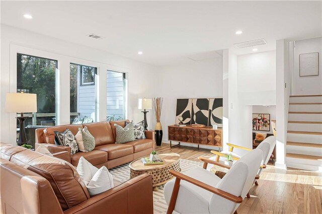living area featuring recessed lighting, stairway, visible vents, and light wood finished floors