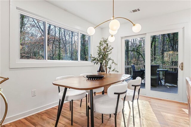 dining room with baseboards, light wood-style flooring, and visible vents