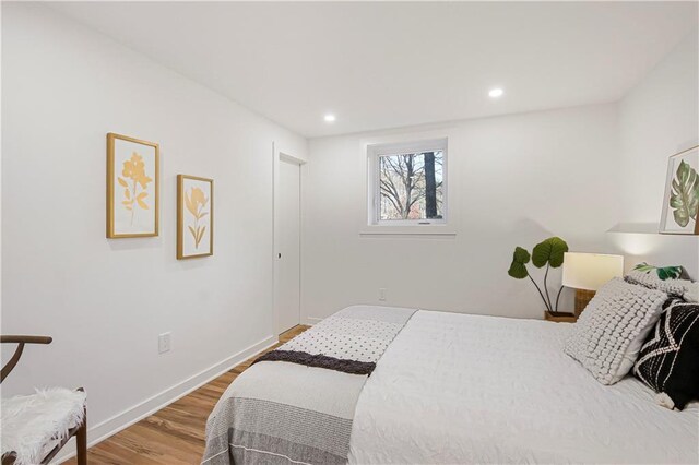 bedroom with recessed lighting, baseboards, and wood finished floors