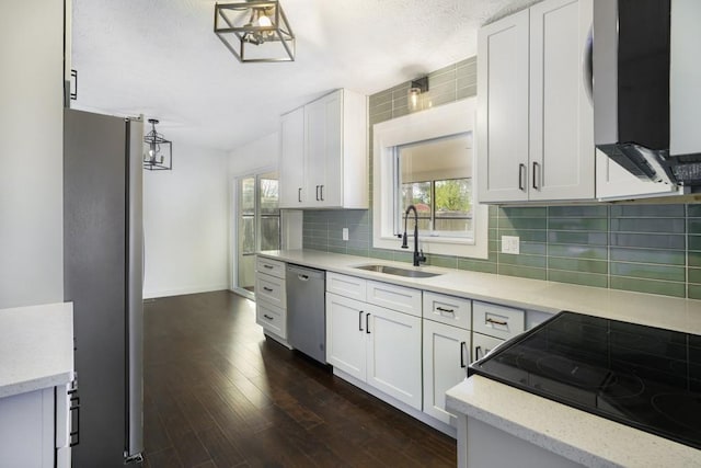 kitchen featuring a sink, backsplash, white cabinets, and appliances with stainless steel finishes