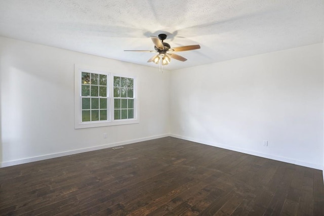 spare room featuring a ceiling fan, a textured ceiling, baseboards, and dark wood-style floors
