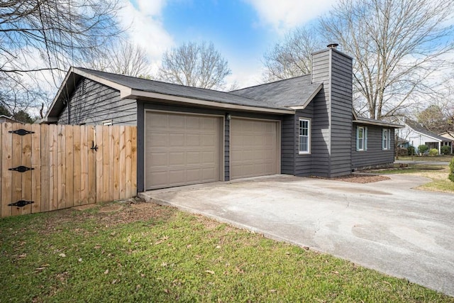 view of side of home featuring fence, an attached garage, a chimney, and driveway