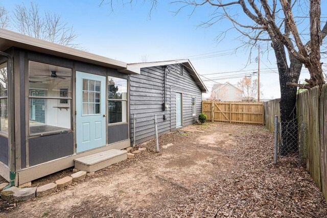 view of home's exterior with a sunroom and a fenced backyard