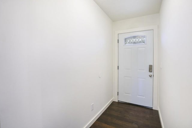 doorway to outside featuring baseboards and dark wood-style flooring