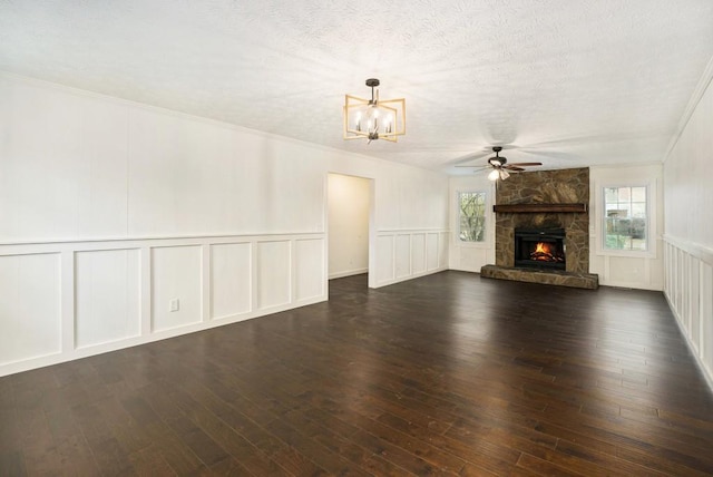 unfurnished living room featuring a decorative wall, plenty of natural light, and ceiling fan with notable chandelier